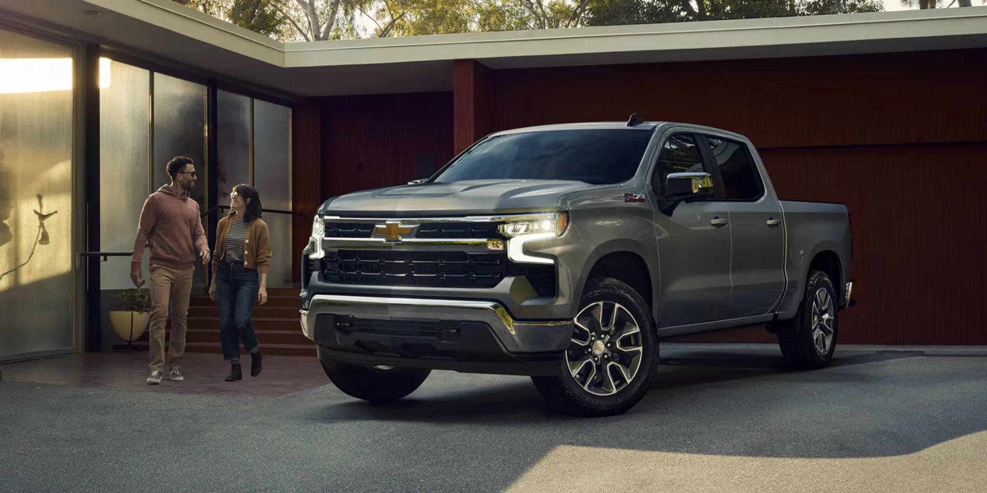 Chevrolet Silverado 1500 2026 gris métallisé garé devant une maison moderne, mettant en valeur son design raffiné et sa polyvalence urbaine.