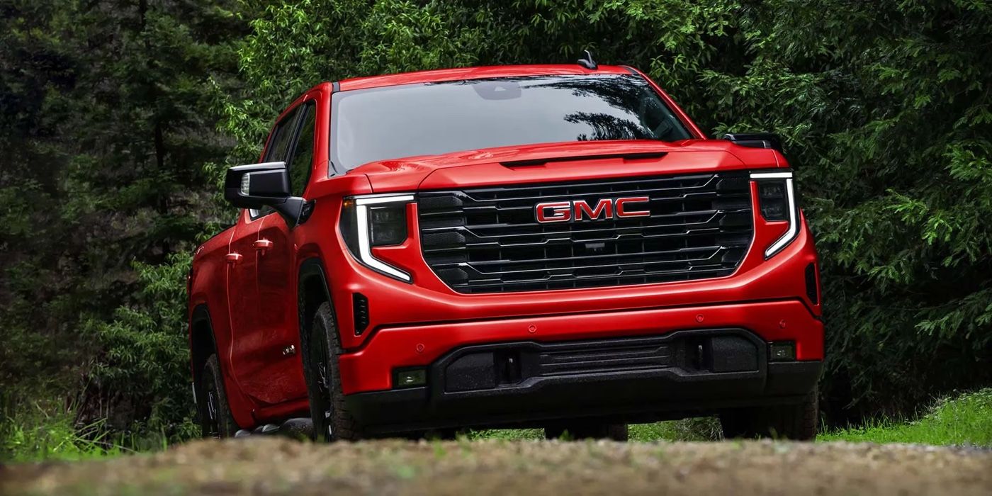 Pickup GMC Sierra 1500 2026 rouge circulant en nature avec une allure robuste et moderne.