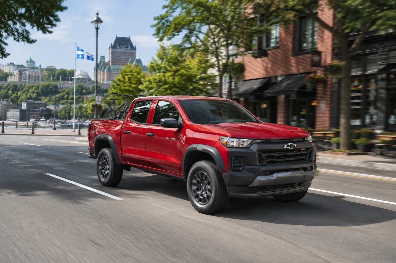 Chevrolet Colorado 2026 rouge roulant dans une rue urbaine.