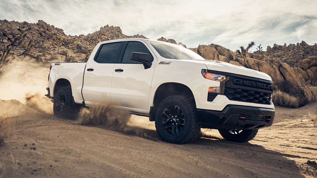 Chevrolet Silverado 1500 2025 blanc roulant dans le désert, démontrant ses capacités tout-terrain et sa puissance.