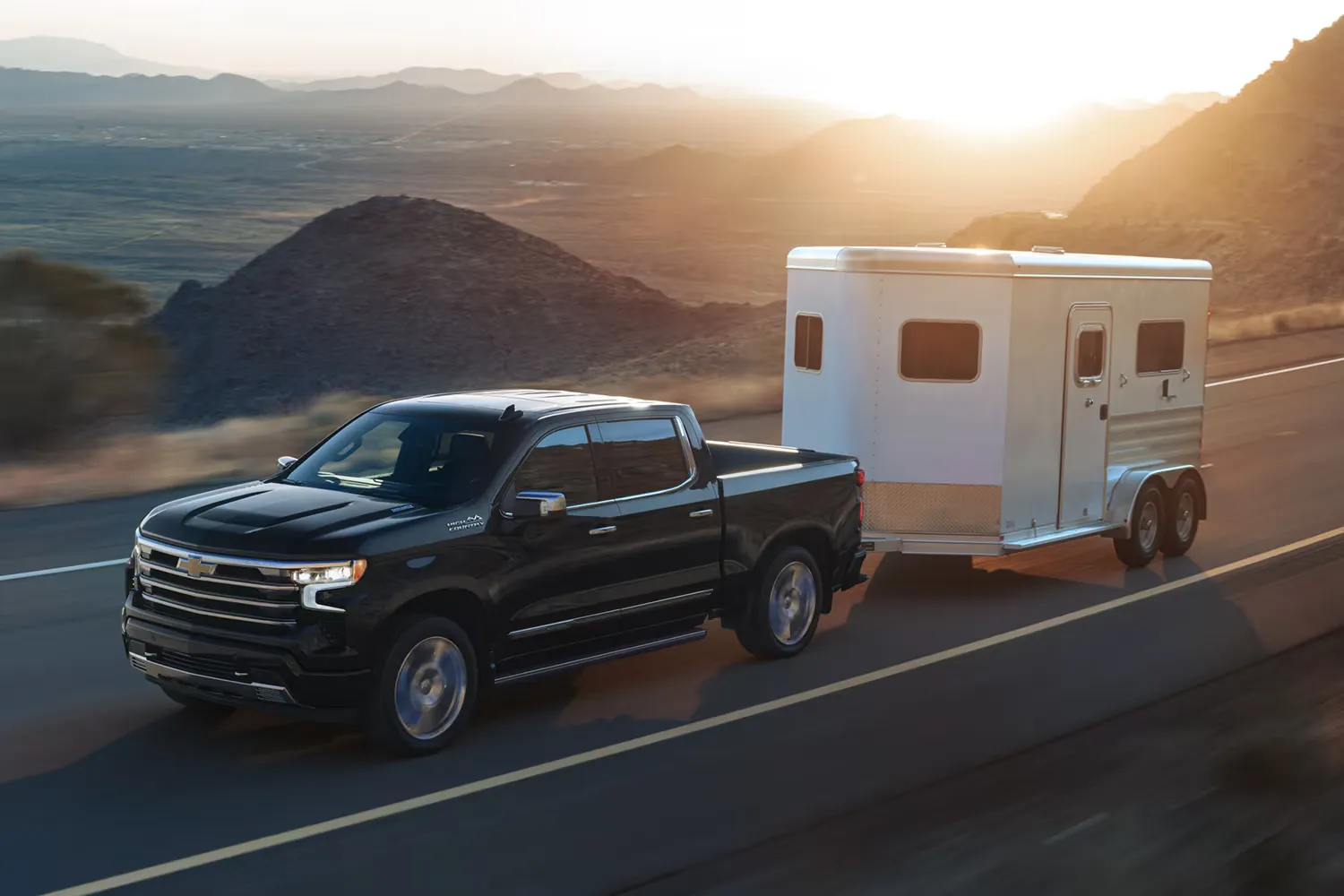 Chevrolet Silverado 1500 2026 noir remorquant une roulotte pour chevaux.