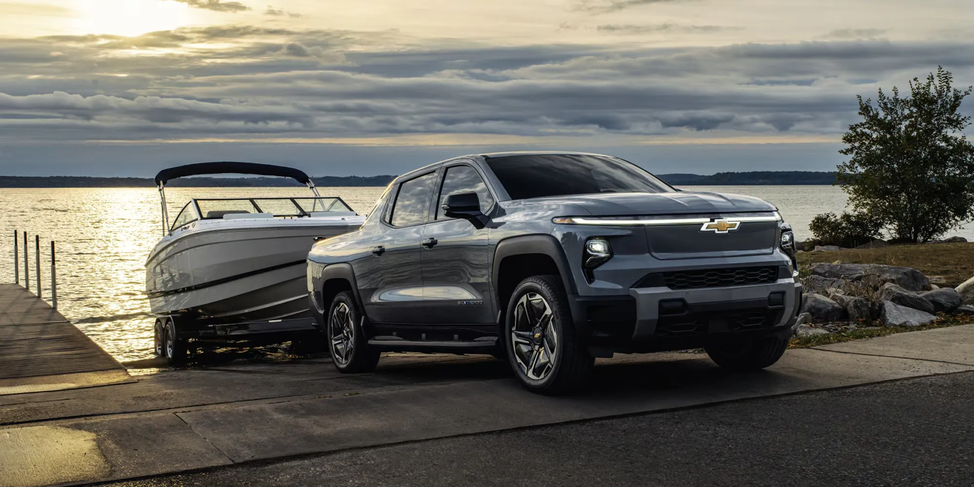 Chevrolet Silverado EV 2026 remorquant un bateau près d’une rampe de mise à l’eau.